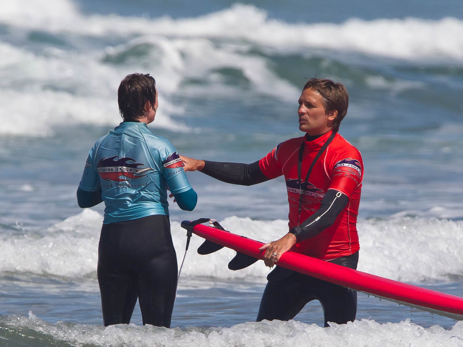 picture of a surf instructor coaching a learner surfer